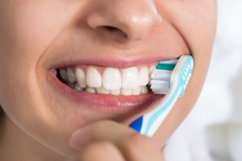 歯ブラシを使って前歯の歯磨きをする女性