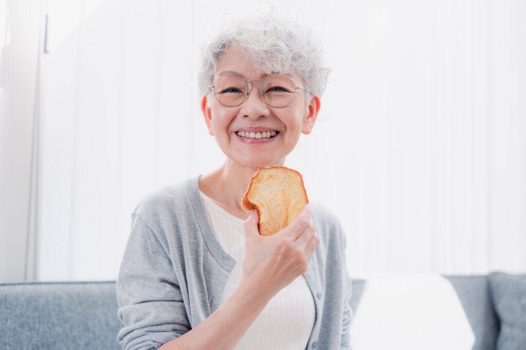 食パンを食べる年配女性