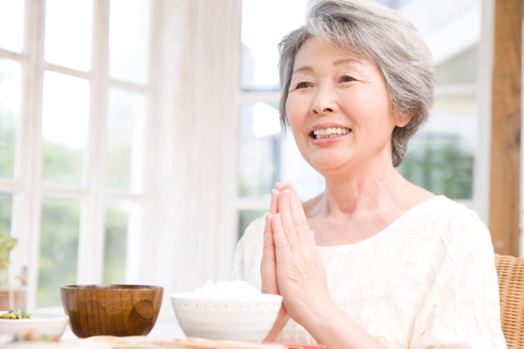 入れ歯治療をし笑顔で食事をする女性