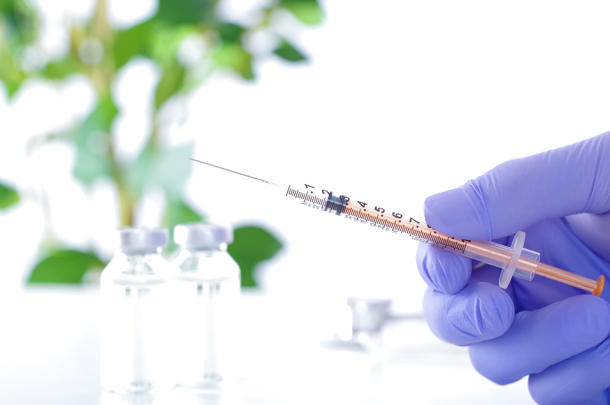 ボツリヌストキシン注射器を持つ医療用グローブをした手