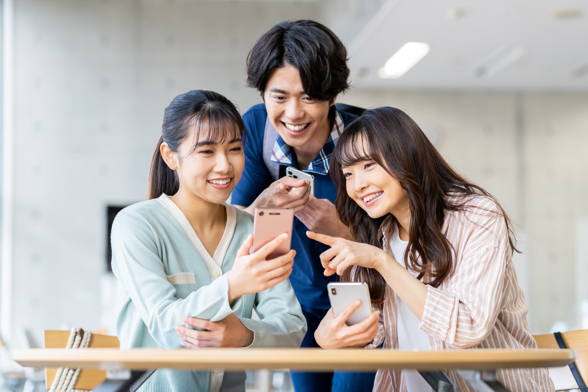 スマホを楽しそうに見ている若者たち