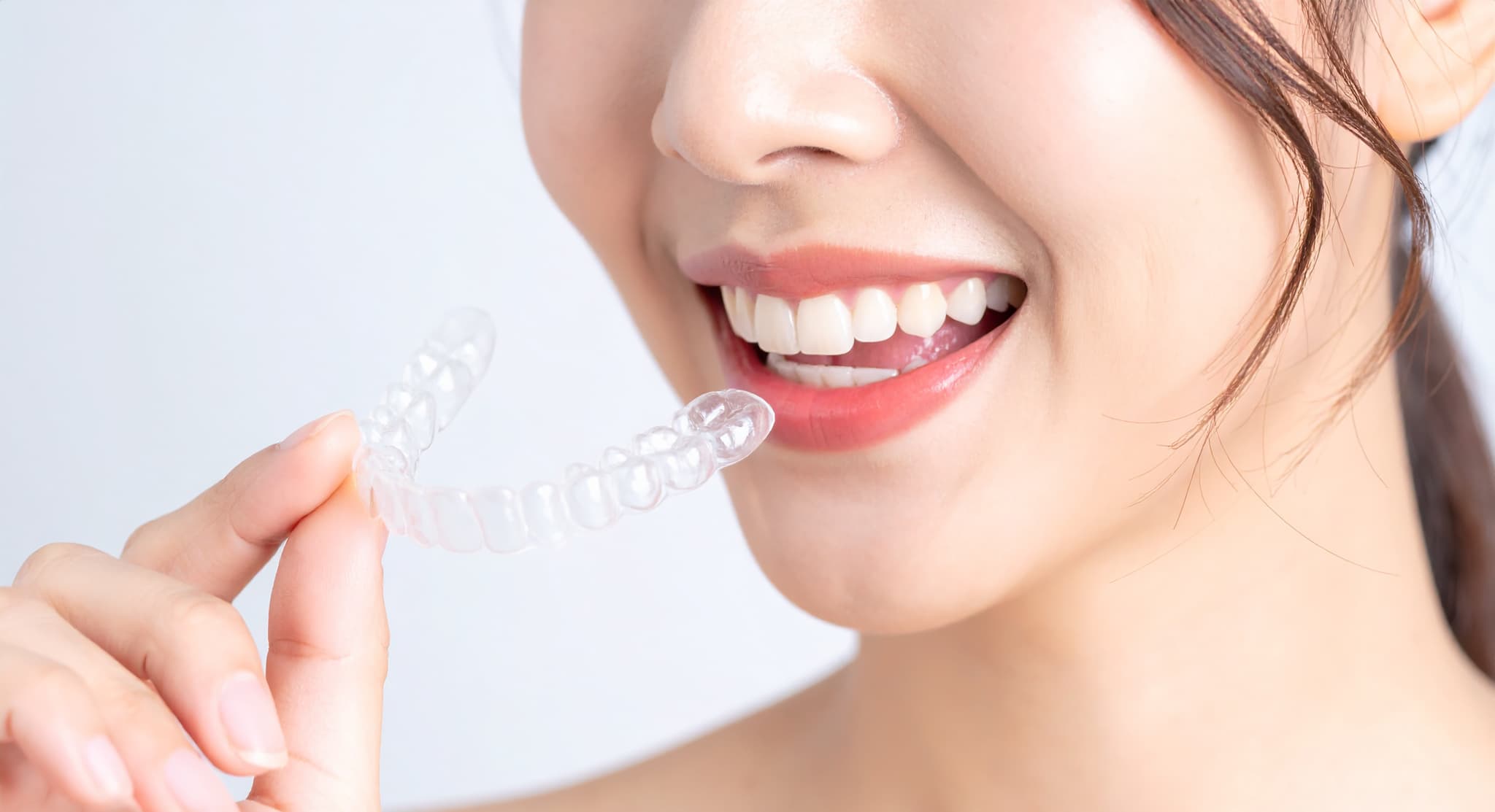 ラミネートベニアを長持ちさせるため就寝時にマウスピースを装着する女性