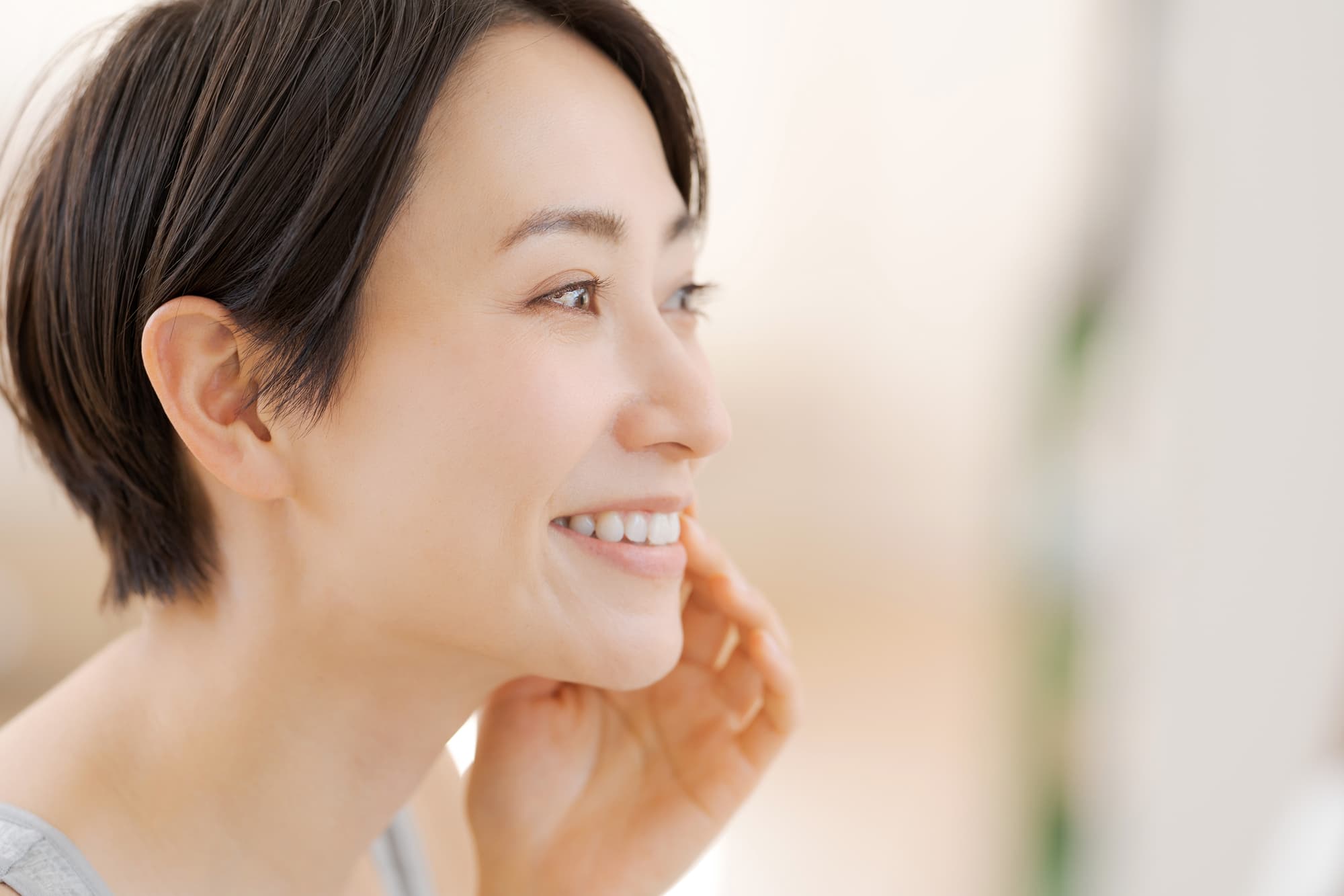 ラミネートべニアで治療した歯を確認して笑顔を見せる女性