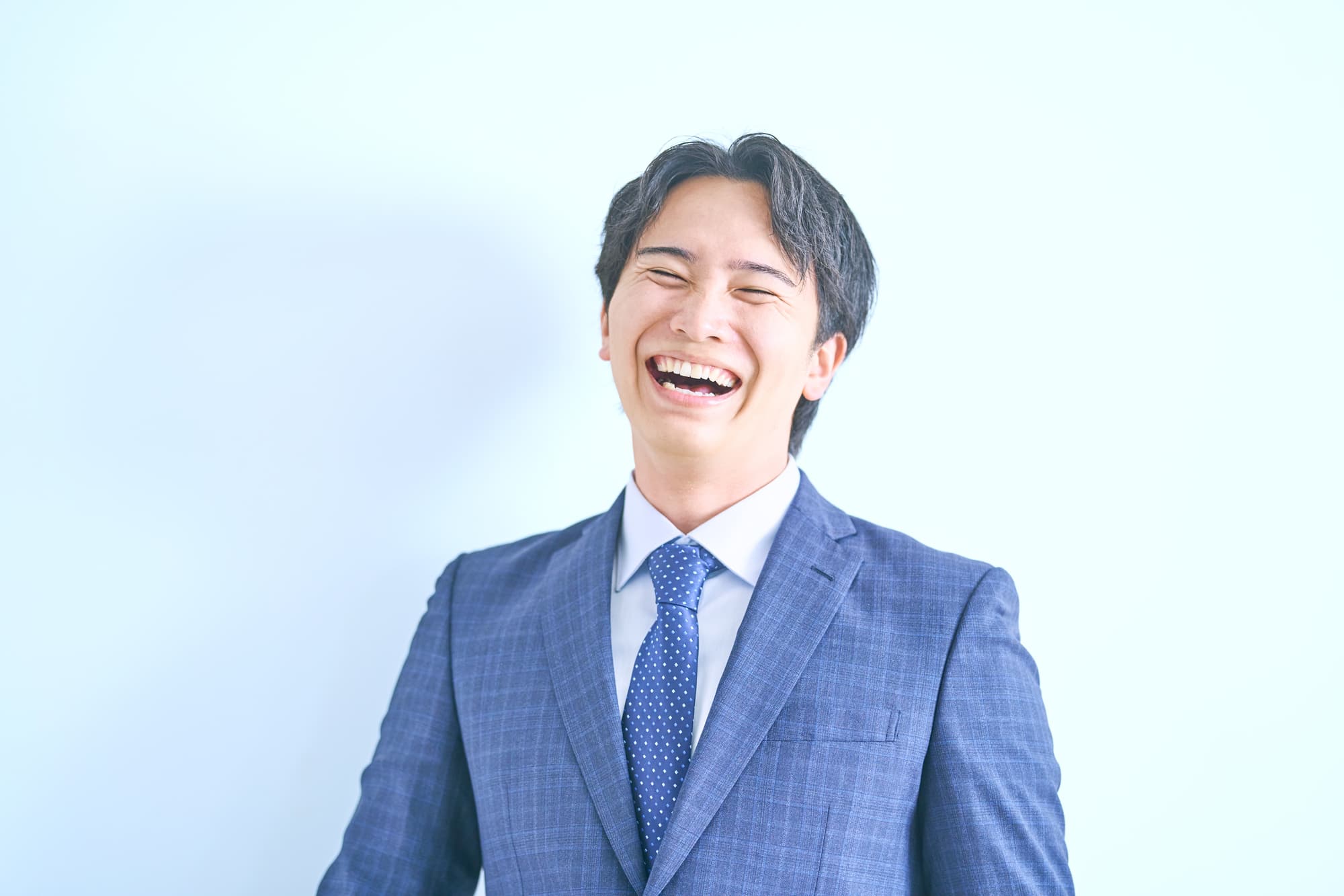 クリーニングをした綺麗な歯に満足して笑うサラリーマン