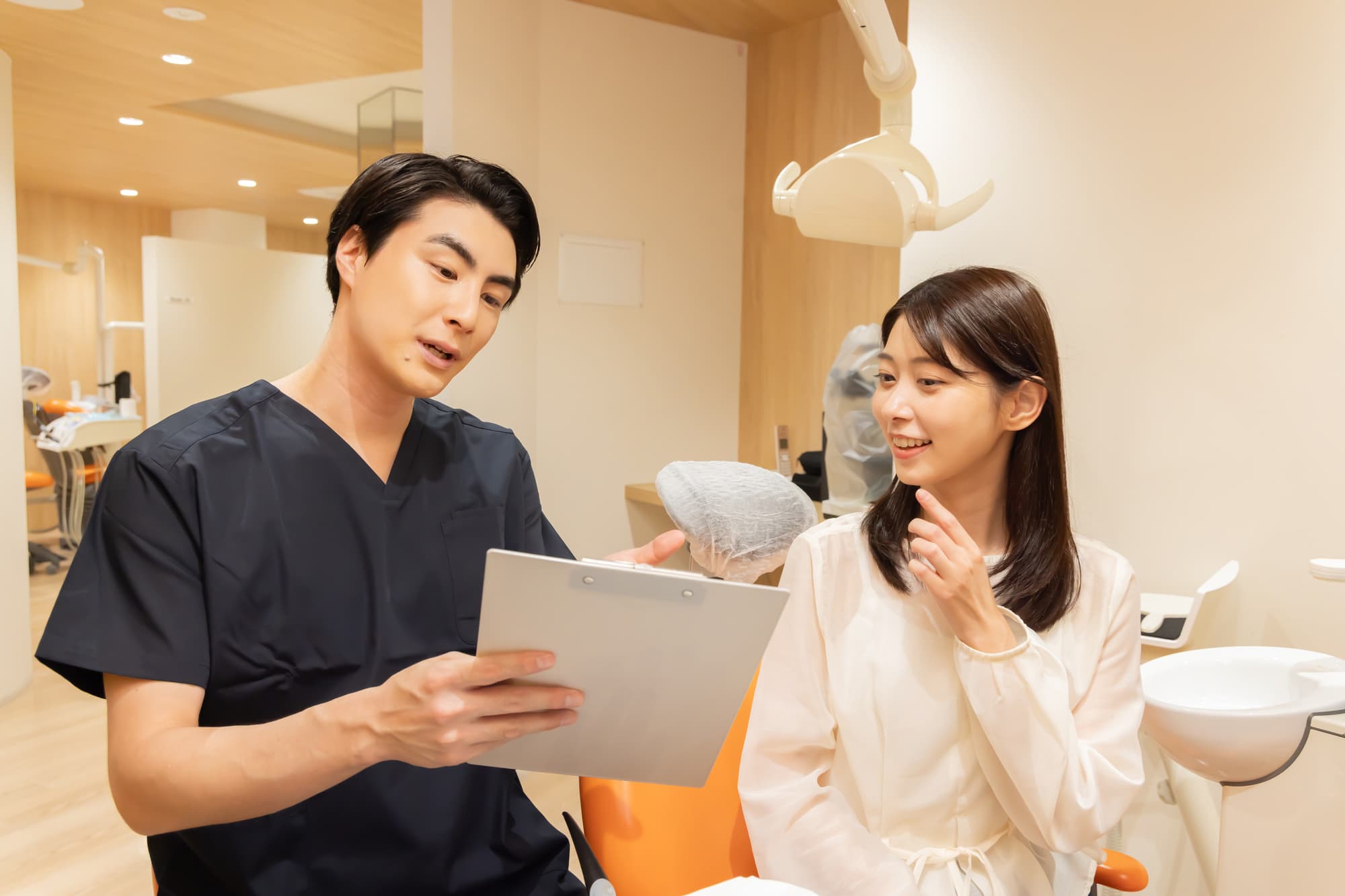 歯のクリーニングによる痛みを軽減するために施術前に歯科医と相談する女性