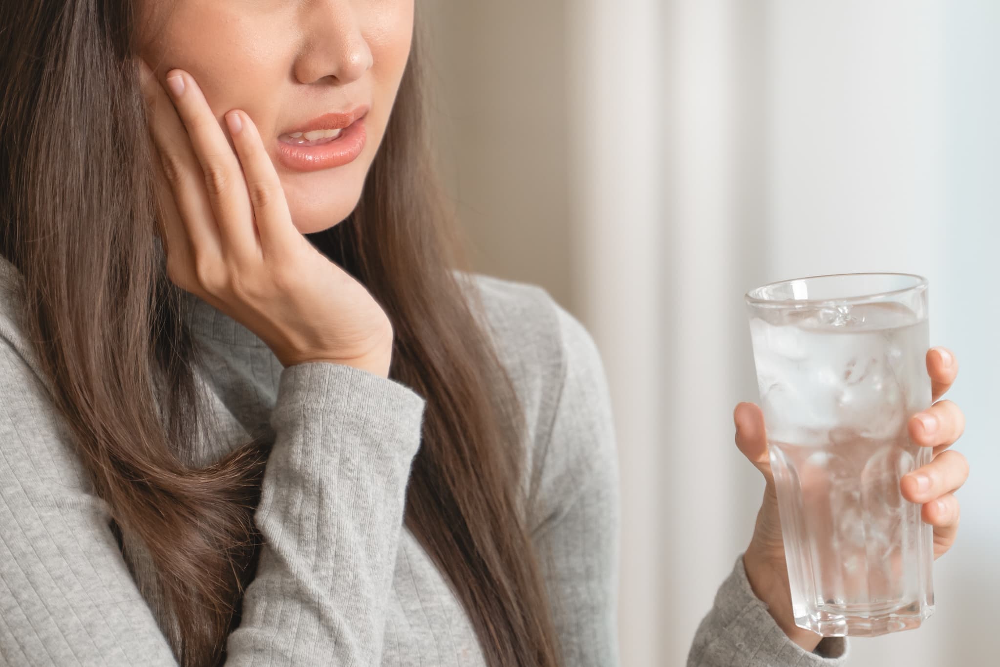冷たい飲み物がしみるようになった女性