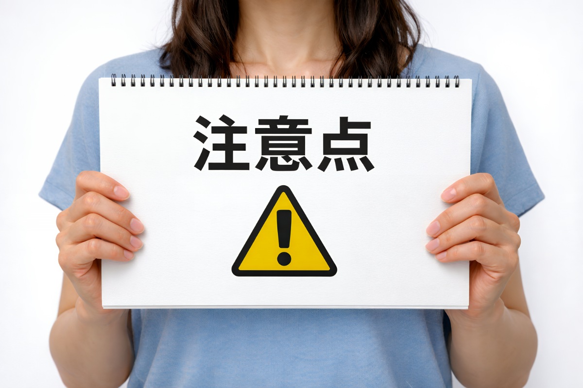 注意点とビックリマークが書かれたスケッチブックを両手に持った人